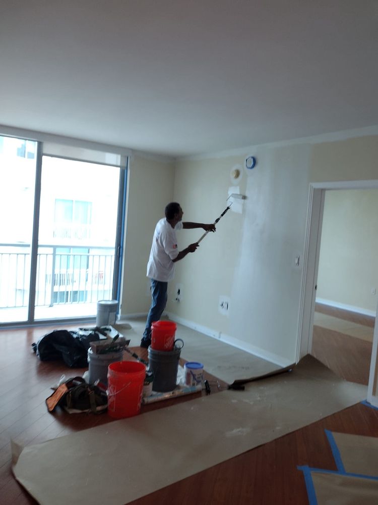 AMR worker painting an interior wall with a roller